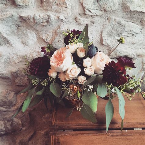 A Bouquet Of Flowers Sitting On Top Of An Old Wooden Box In Front Of A