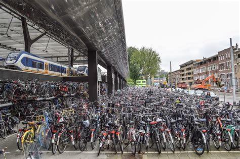 Many Bicycles Are Lined Up On The Side Of The Street Near A Train