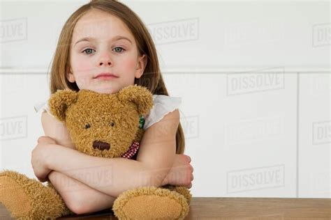 Girl Hugging Teddy Bear At Table Stock Photo Dissolve
