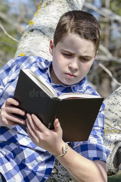 Jonge Jongen Die Een Boek In Het Hout Met Ondiepe Diepte Van Gebied