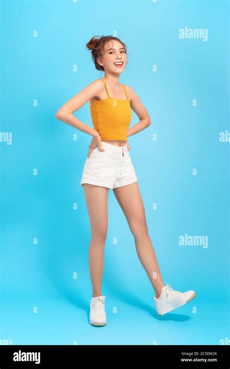 Full Length Photo Of Long Legged Girl In White Shorts And Cropped Top On A Blue Background Stock