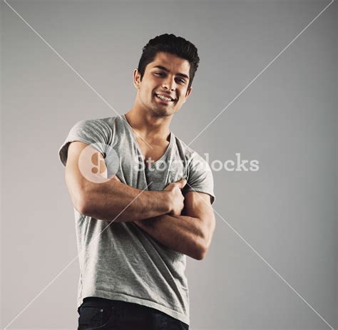 Portrait Of Confident Young Man Posing Against Neutral Background