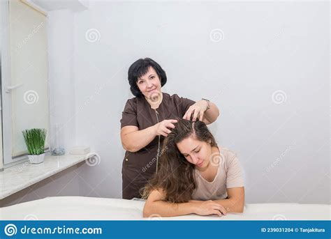 A Female Masseuse Makes A Head Massage To A Young Beautiful Girl Who Is
