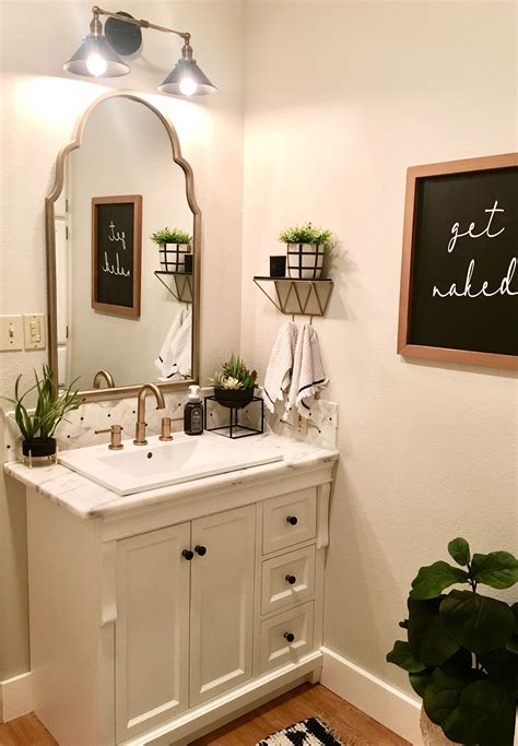 A Bathroom With A Sink Mirror And Potted Plants