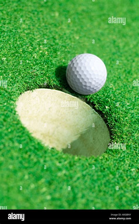 Golf Ball On Edge Of Hole On Golf Green Stock Photo Alamy