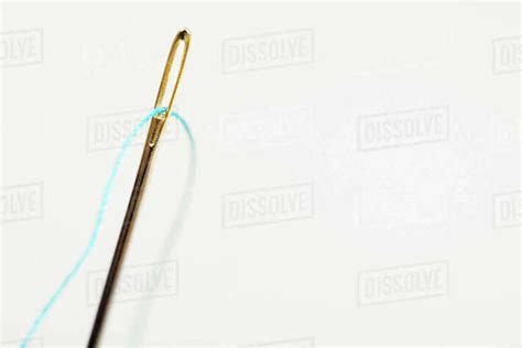 Sewing Needle With Blue Thread Through Eye Stock Photo Dissolve