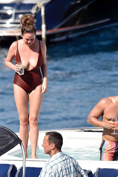 Chrissy Teigen Relaxes On A Yacht In A Brown Swimsuit