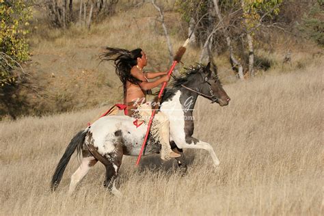 A Native American Indian Man Riding Bareback On A Horse In The Prairie