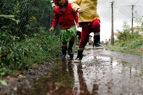 Two Girls Playing In The Street After The Rain Del Colaborador De Stocksy Léa Jones Stocksy