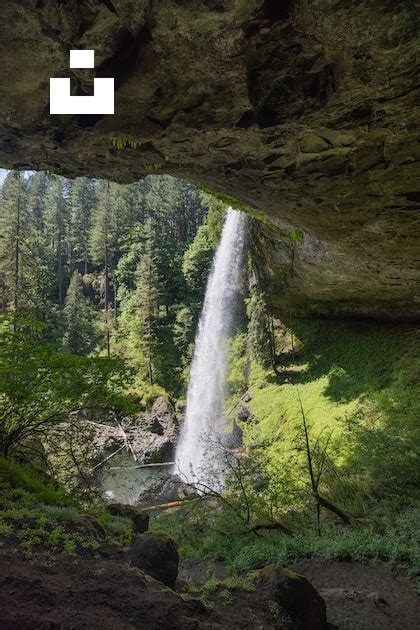 A Large Waterfall Is Coming Out Of A Cave Photo Free Usa Image On