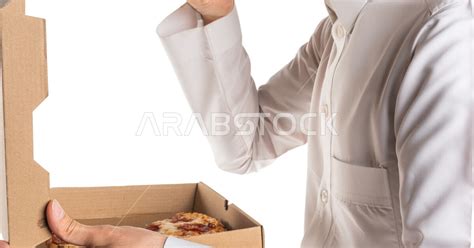 بورتريه لرجل عربي سعودي خليجي يحمل بيده فطيرة البيتزا تناول وجبة طعام غير صحيه خدمات توصيل