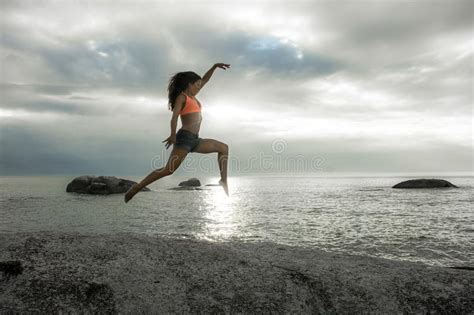 Woman Jumping On A Rock At Sunset On Bakovern Beach Cape Town Stock Photo Image Of Dusk