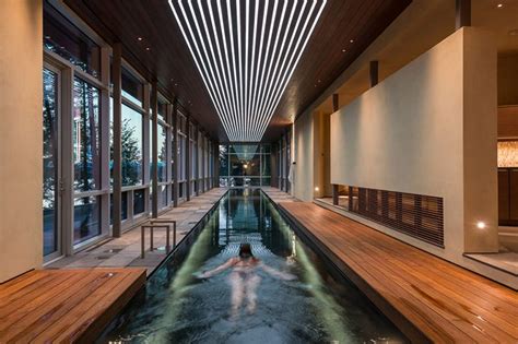 A Woman Is Swimming In The Water Inside An Indoor Pool With Wooden