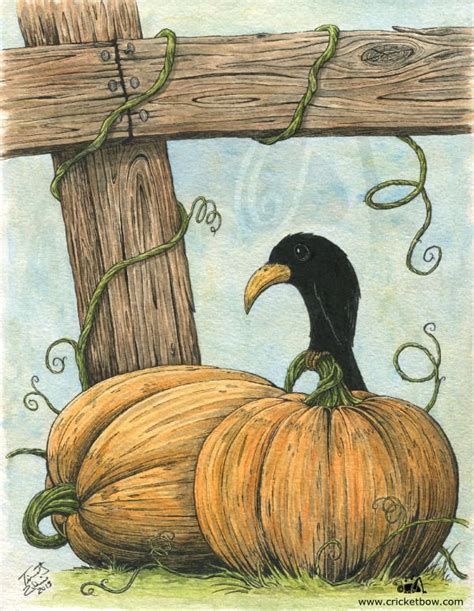 A Black Bird Sitting On Top Of Two Pumpkins Next To A Wooden Fence Post