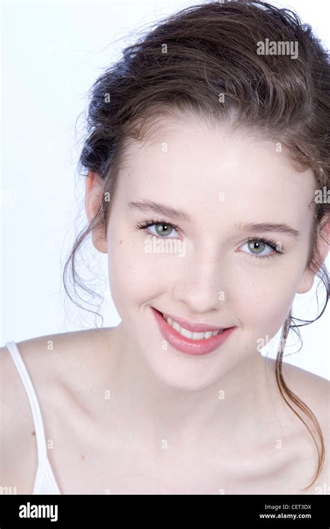 female with brunette hair off her face with clean pale skin and natural make up smiling