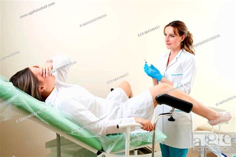 Gynecologist Preparing For An Examination Procedure For A Woman Sitting