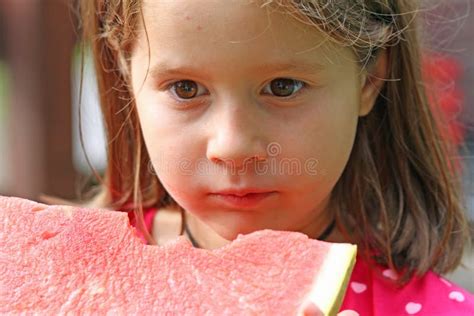 Cute Girl Brunette Eats A Huge Slice Of Red Watermelon Stock Image
