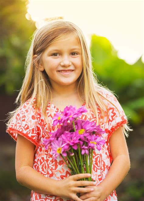 retrato de una niña linda sonriente con las flores foto de archivo imagen de cara afuera