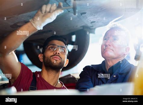 Male Mechanics Working Under Car In Auto Repair Shop Stock Photo Alamy