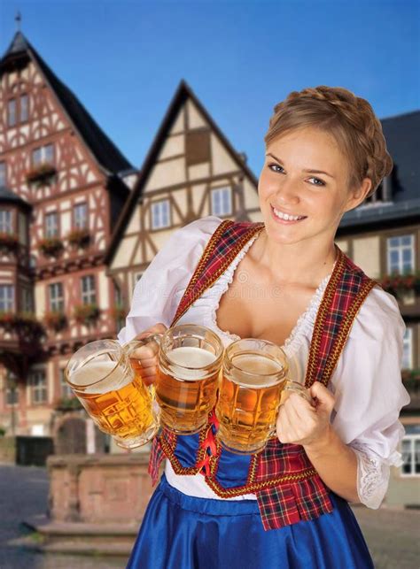 den unga sexiga oktoberfest servitrins och att bära en traditionell bayersk klänning tjänande