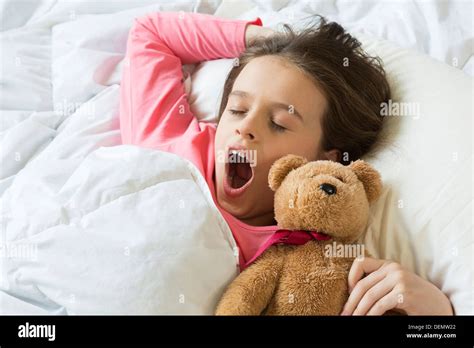 Young Girl Waking Up Yawning In Bed Stock Photo Royalty Free Image