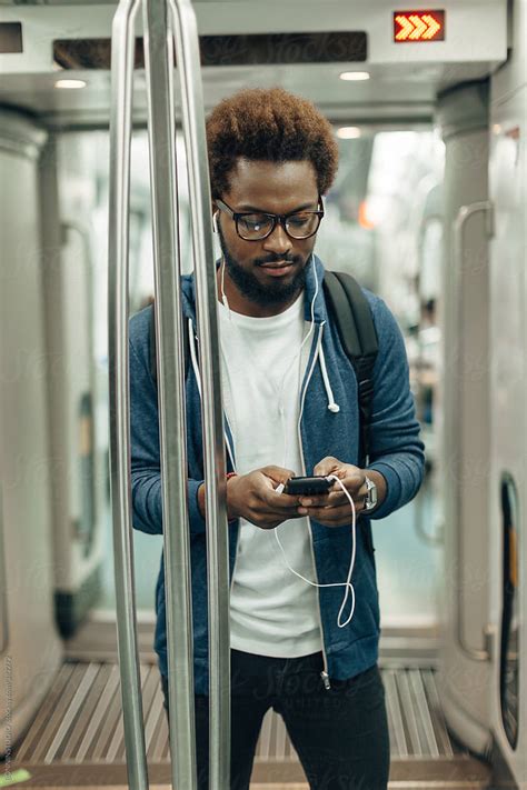 Young Afro Black Man Using Mobile Phone While Listening Music On The