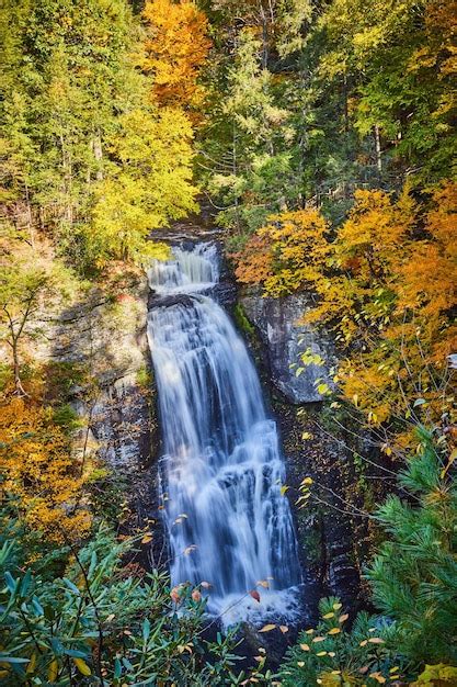 Premium Photo Large Waterfall Over Cliffs Surrounded By Fall Foliage