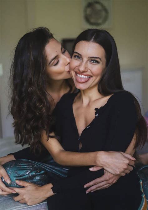 Two Women Are Kissing Each Other On The Bed