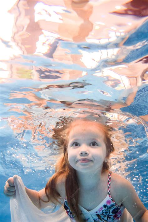 Маленькая девочка плавает под водой в детском бассейне дайвинг малыш