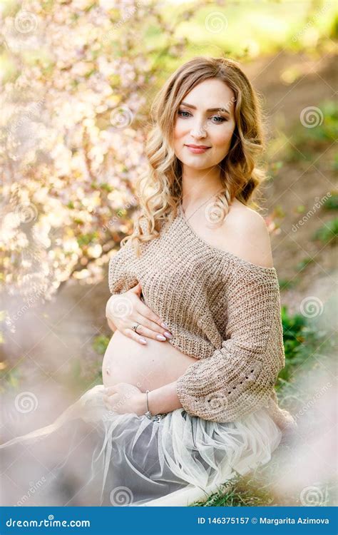Beautiful Pregnant Woman Sitting Near The Cherry Blossom Pregnant Happy Pretty Woman In Blossom