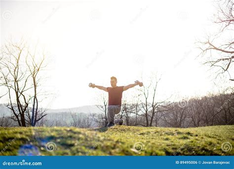 Young Man Eercise In Nature Lifting His Arms With Weights Stock Photo