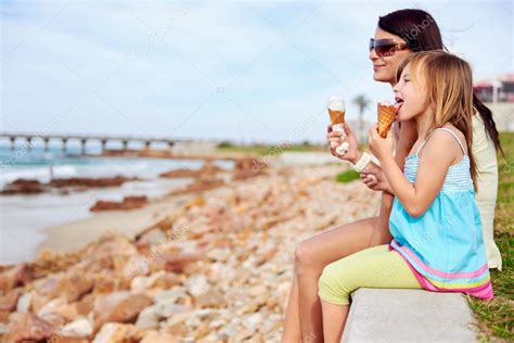 Mamá y su hija disfrutan del helado en la playa fotografía de stock Daxiao Productions