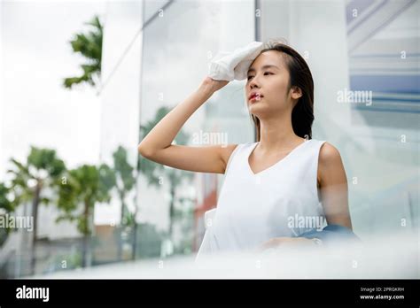 asian beautiful business woman drying sweat her face with cloth in warm summer day hot weather