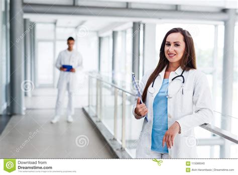 Young Nurse Posing In Front Of Her Colleague Stock Photo