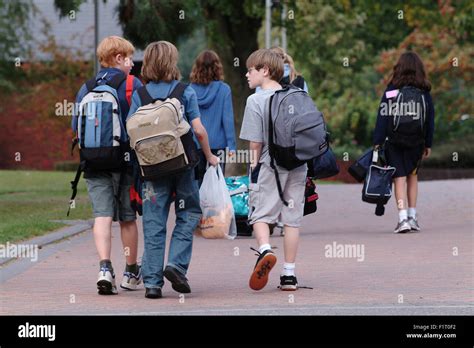 Children Leaving School With Backpacks Walking Away From Camera Stock