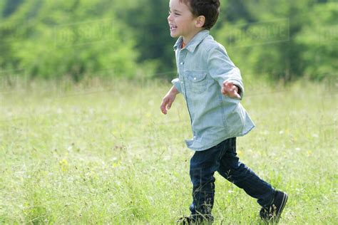 Little Boy Running In Meadow Side View Stock Photo Dissolve