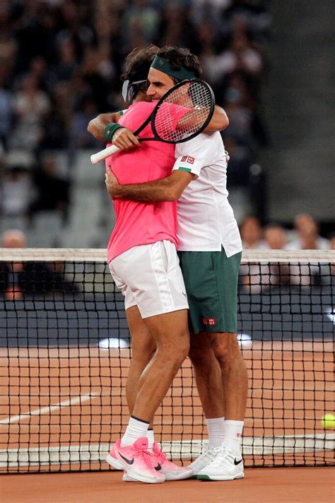 Two Tennis Players Hugging Each Other On The Court