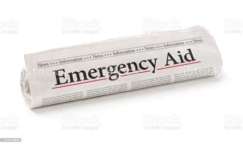 Rolled Newspaper With The Headline Emergency Aid Stock Photo Download