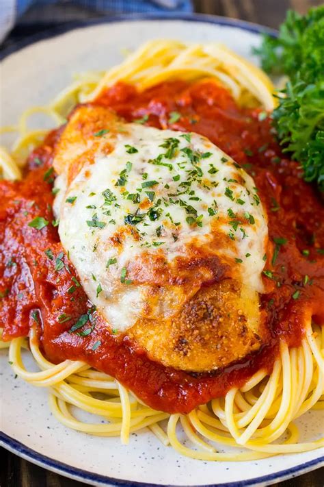 Baked Chicken Parmesan Served Over Spaghetti With Tomato Sauce In