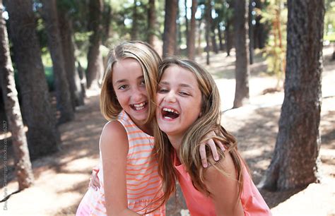Two Young Girls Laughing In Park By Dina Giangregorio Stocksy United