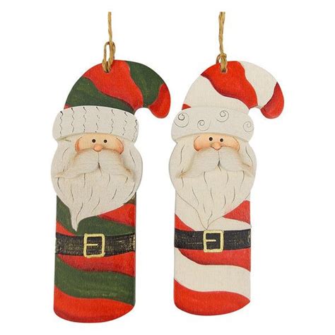 Two Wooden Santa Claus Ornaments Hanging From Hooks On A White