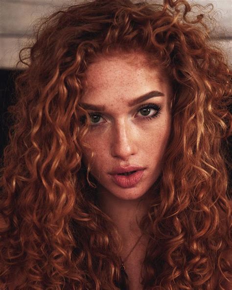 A Close Up Of A Woman With Red Curly Hair
