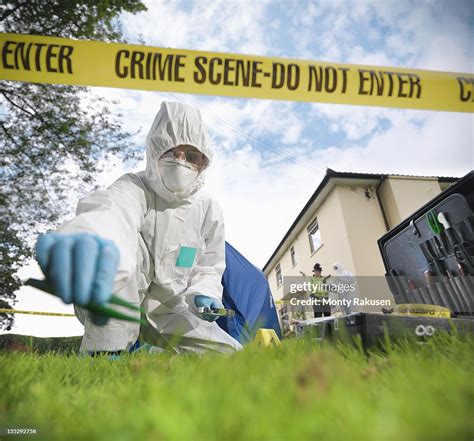 Close Up Of Forensic Scientist Taking Sample At Crime Scene Surface