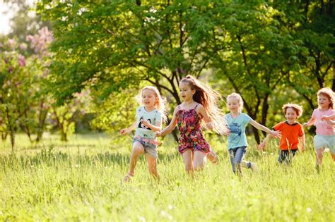 Un Grupo De Niños Felices De Niños Y Niñas Corren En El Parque En El