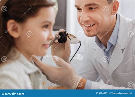 Positive Delighted Medical Worker Treating Ear Of Patient Stock Image
