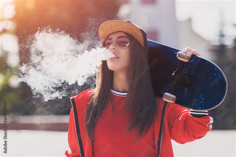 Vaping Girl Young Woman With Skateboard Vape E Cig Pretty Young Female In Black Hat Red