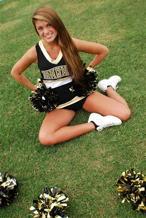 A Cheerleader Sitting On The Ground With Her Hands Behind Her Back