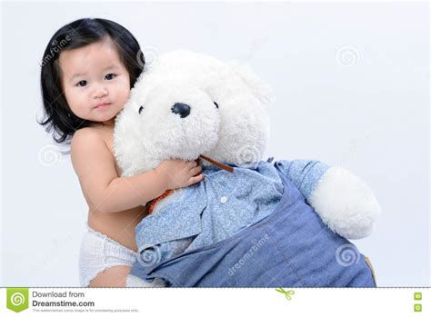 Adorable Little Asian Girl Hugging A Teddy Bear On White Background
