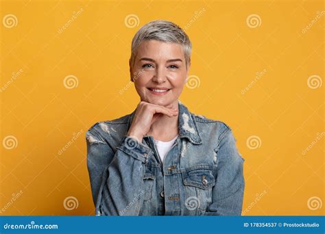 Portrait Of Confident Mature Lady Touching Chin And Smiling At Camera