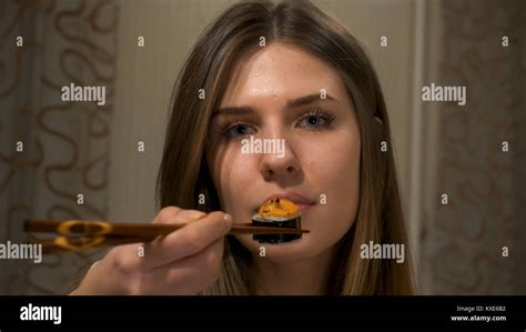 Young Attractive Woman Eating Sushi With A Chopsticks Brunette Girl